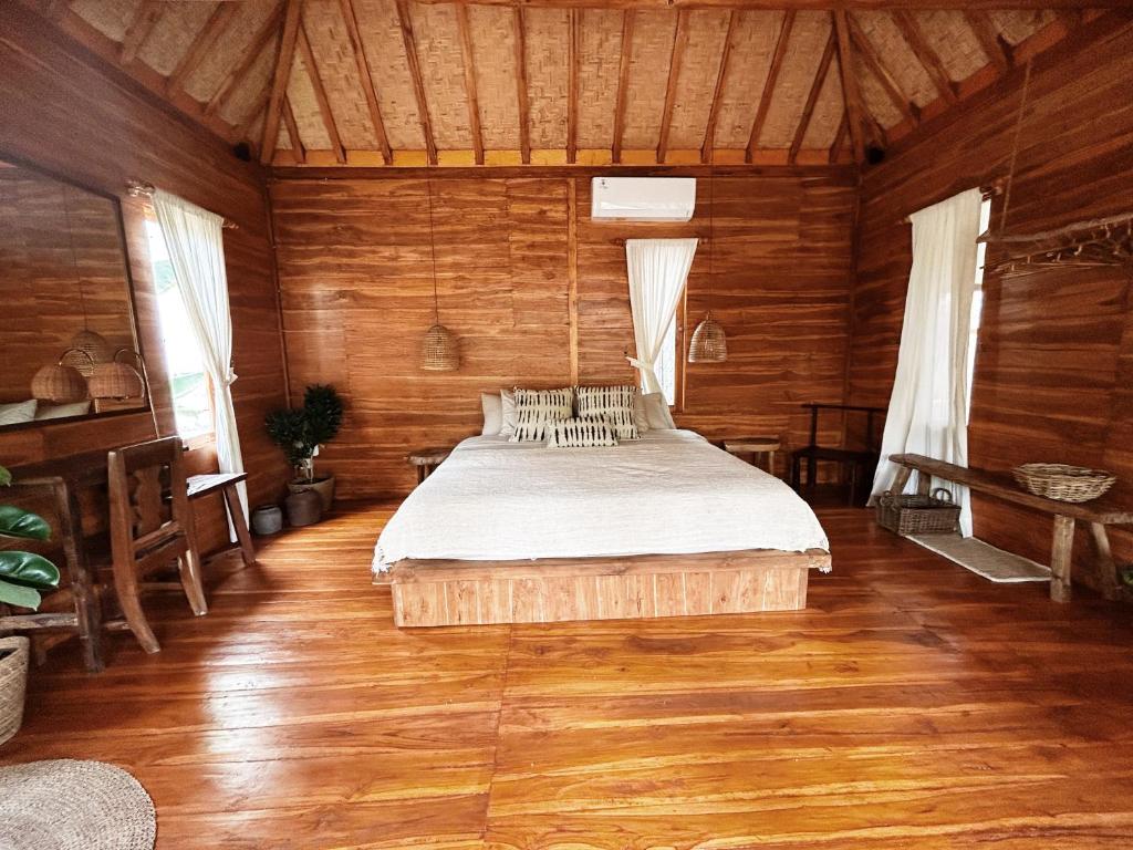 um quarto com uma cama num quarto de madeira em La pipa Uluwatu em Uluwatu