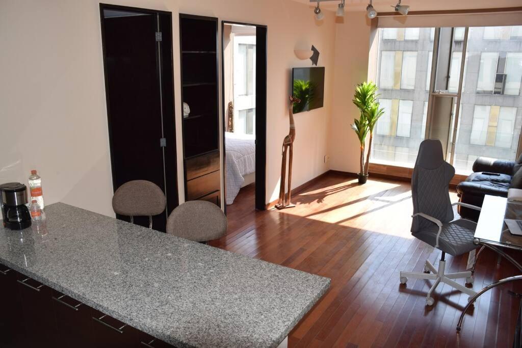 eine Küche mit einer Theke und Stühlen in einem Zimmer in der Unterkunft Acogedor y hermoso depto, en el C.Historico CDMX in Mexiko-Stadt