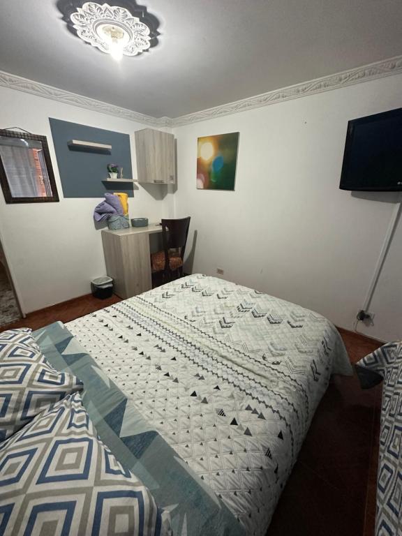 1 dormitorio con cama con edredón en Habitaciones pacheco, en Bogotá