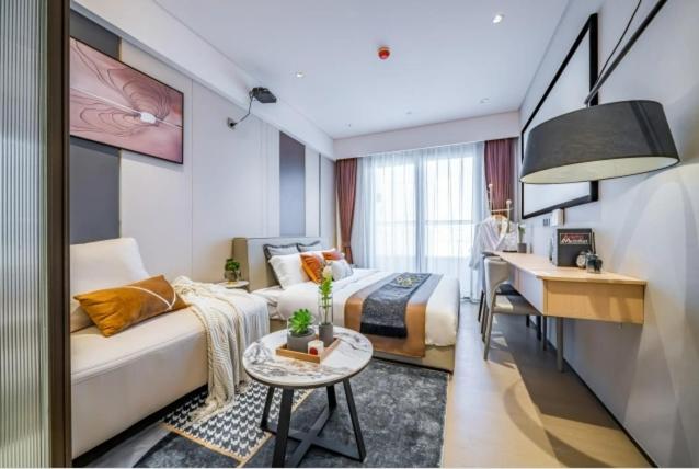 a hotel room with a bed and a desk and a bedroom at Raffles Executive Apartment - Guangzhou Huijin International Finance Center, Keyun Road Metro Station Branch-Canton Fair Free Shuttle in Guangzhou