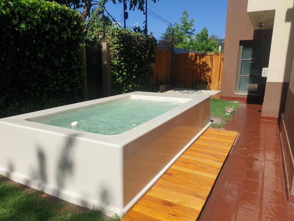 uma banheira de hidromassagem no quintal de uma casa em Chacras de Coria Los Robles em Chacras de Coria