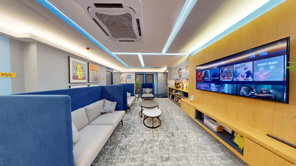ein Wohnzimmer mit einem Sofa und einem großen TV in der Unterkunft Blue Lagoon At Bandar Sunway in Petaling Jaya