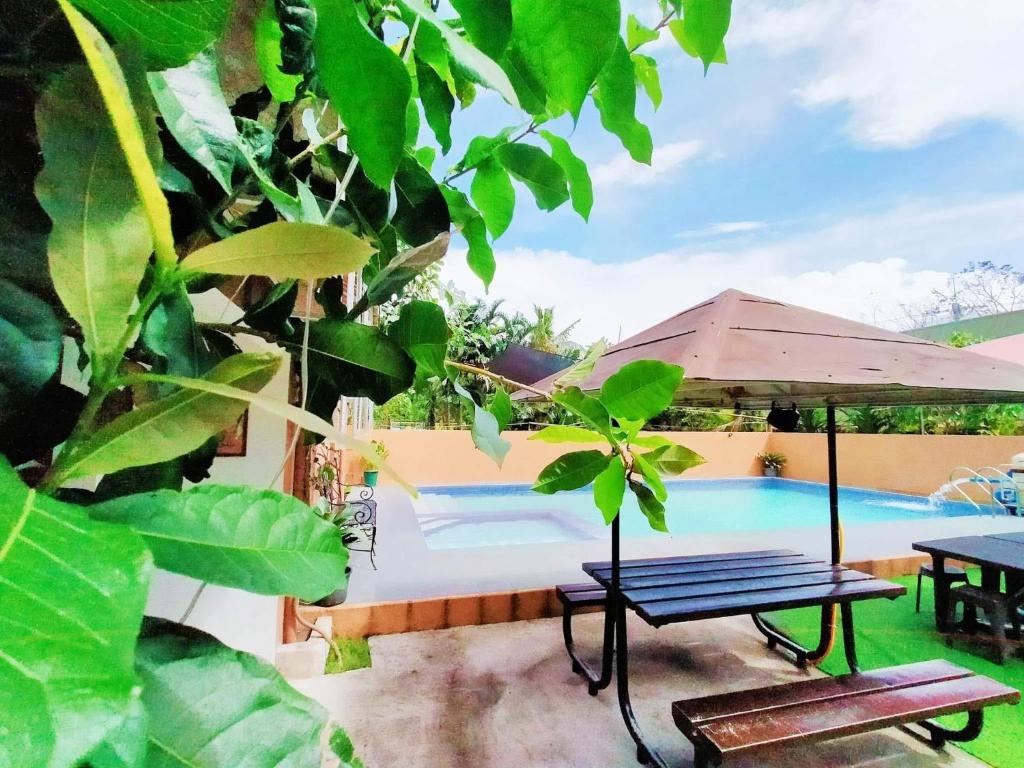 un patio con mesa y piscina en Home in Real, en Cavinti