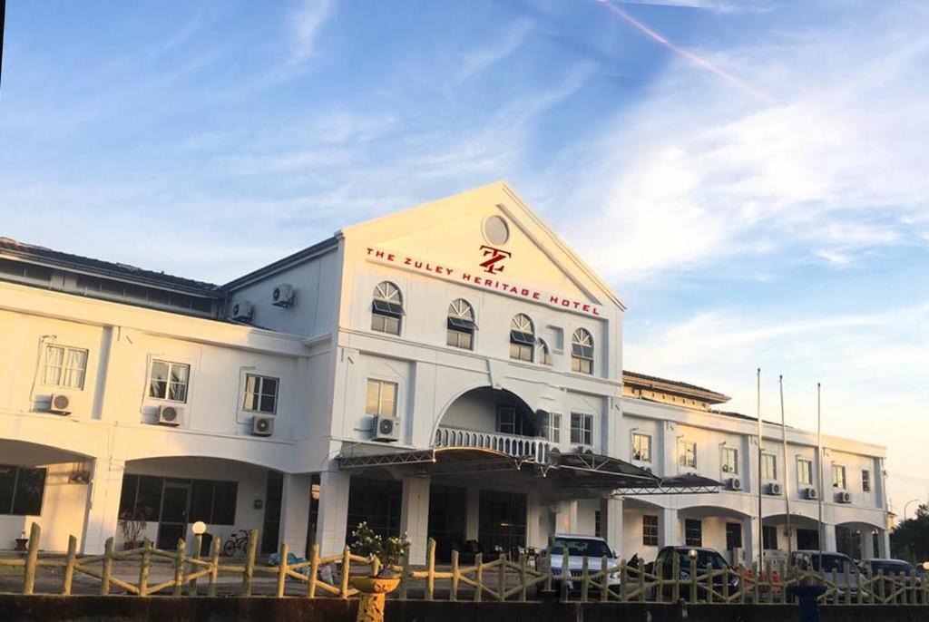 um grande edifício branco com um cartaz em THE ZULEY HERITAGE HOTEL em Kuala Perlis