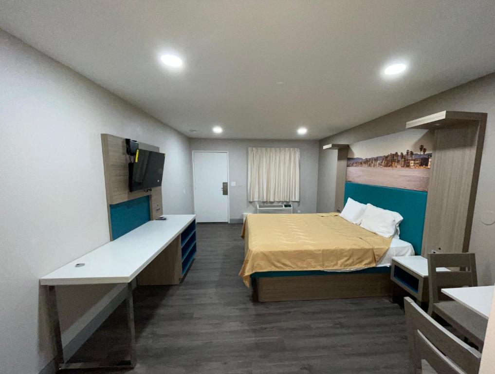 a bedroom with a bed and a desk in it at New Star Inn El Monte, CA - Los Angeles in El Monte