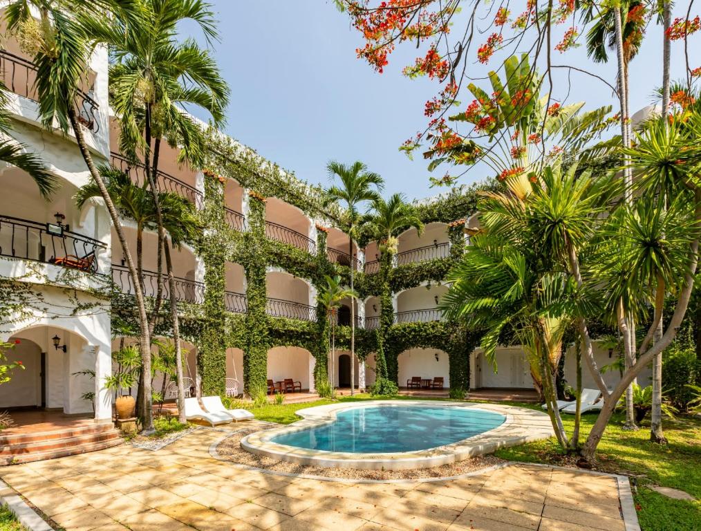 una vista exterior de un complejo con piscina y palmeras en Palm Springs Hotel en Chiang Mai