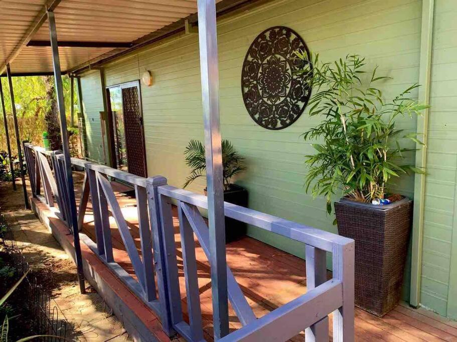 eine Veranda eines grünen Hauses mit Pflanzen drauf in der Unterkunft The Garden Cottage Pet Friendly in Renmark
