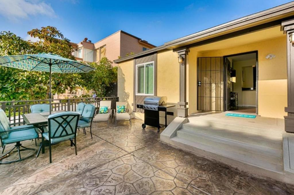 eine Terrasse mit einem Tisch, Stühlen und einem Sonnenschirm in der Unterkunft Riviera Bay View Dream - Private patio with bay view and parking in San Diego