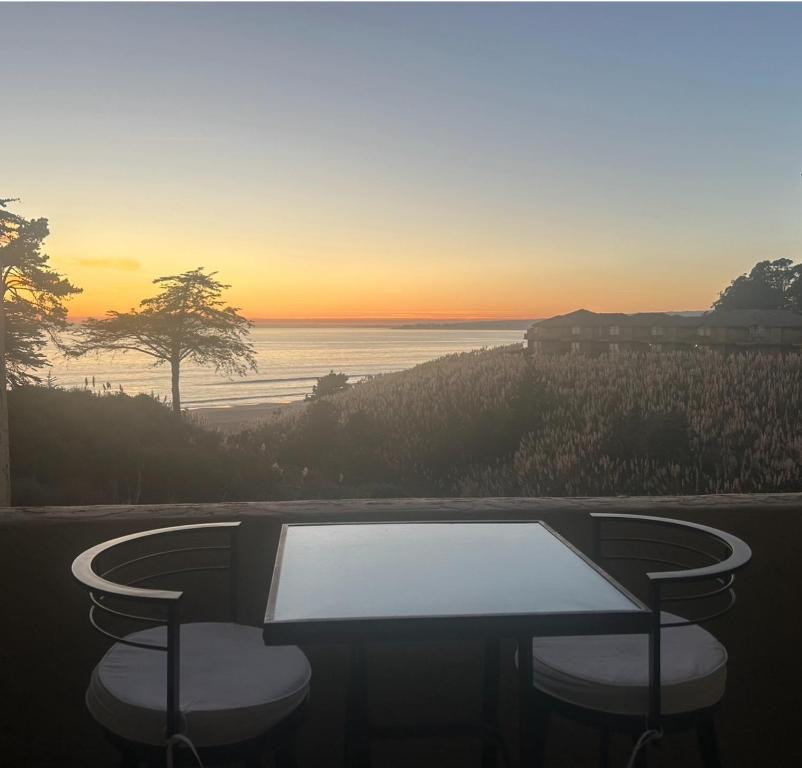 a table and two stools in front of a sunset at Seascape Resort Aptos, Capitola, Santa Cruz in Aptos