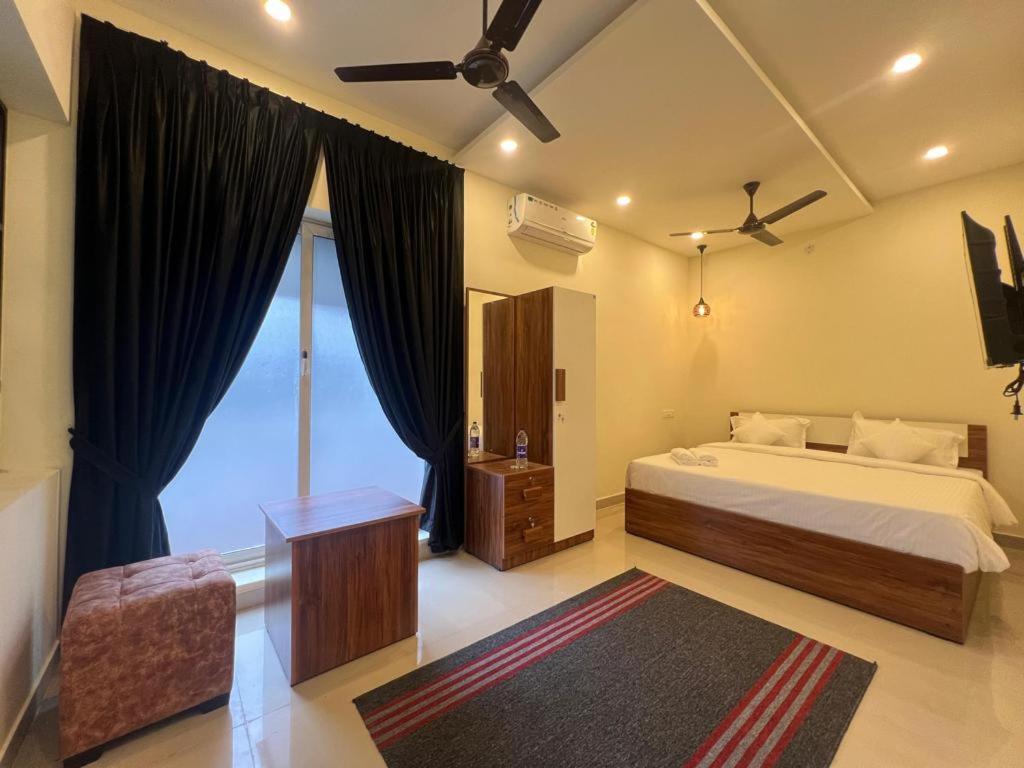 a bedroom with a bed and a large window at Cloud Beach Residency in Alleppey