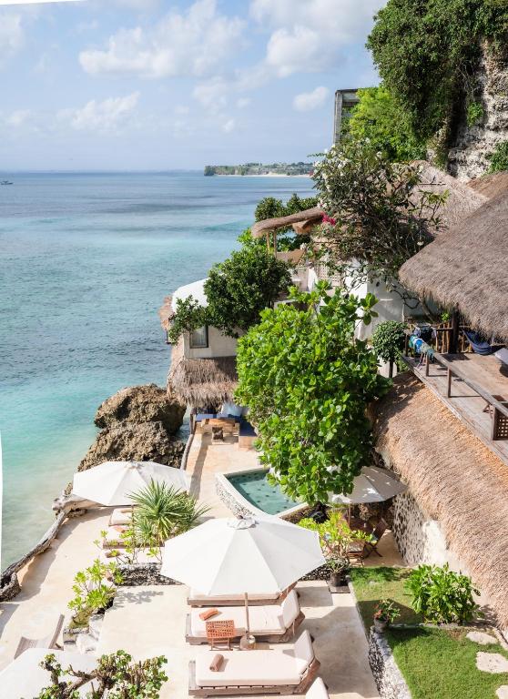 an aerial view of a resort with a swimming pool and the ocean at Rock'n Reef in Uluwatu
