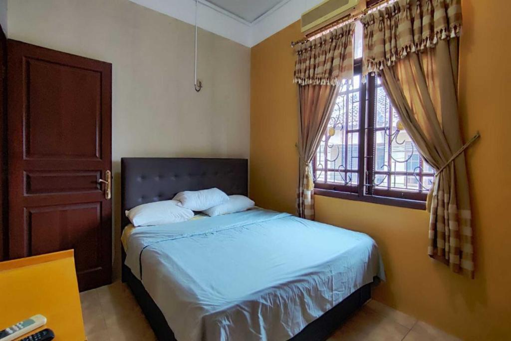 1 dormitorio con cama y ventana en OYO 93390 Griya Pius Syariah Malioboro, en Yogyakarta