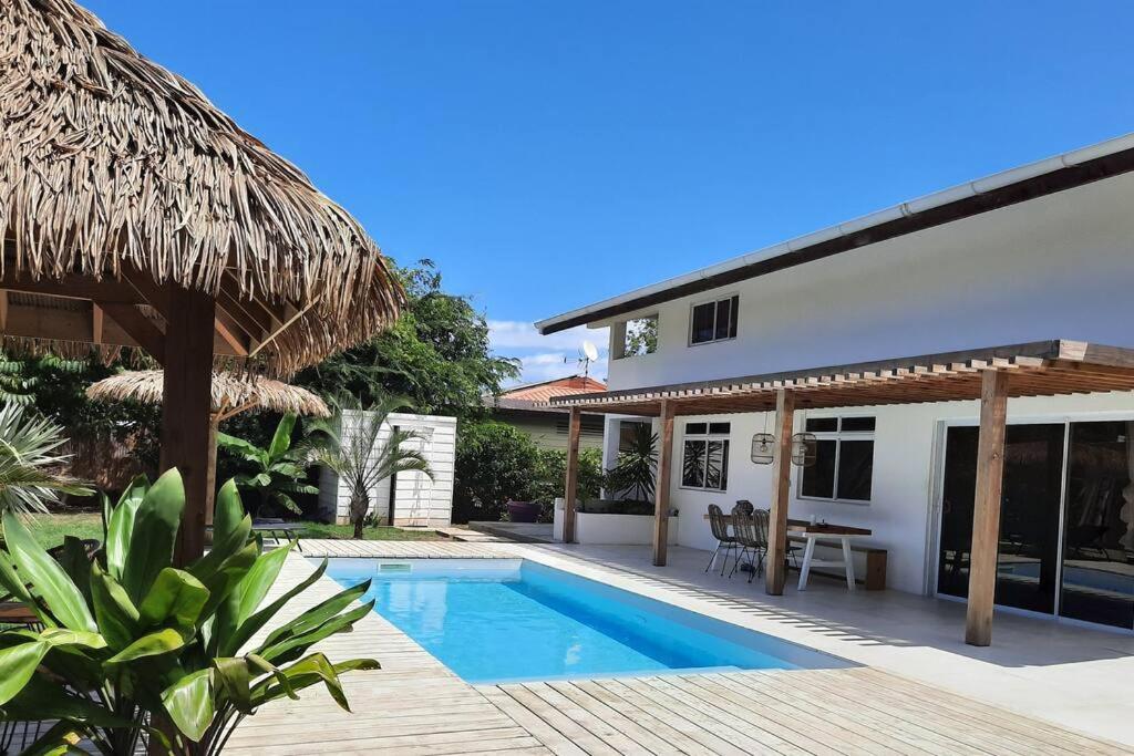 une villa avec une piscine et une maison dans l'établissement Charmante villa de vacances à Moorea, à Afareaitu