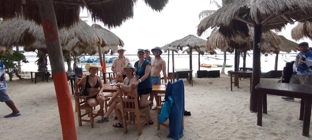 a group of people sitting at a table on the beach at Maha cabin beach access in Mahahual
