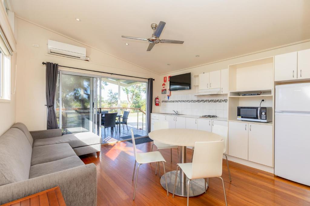 a kitchen and living room with a couch and a table at NRMA Eastern Beach Holiday Park in Lakes Entrance