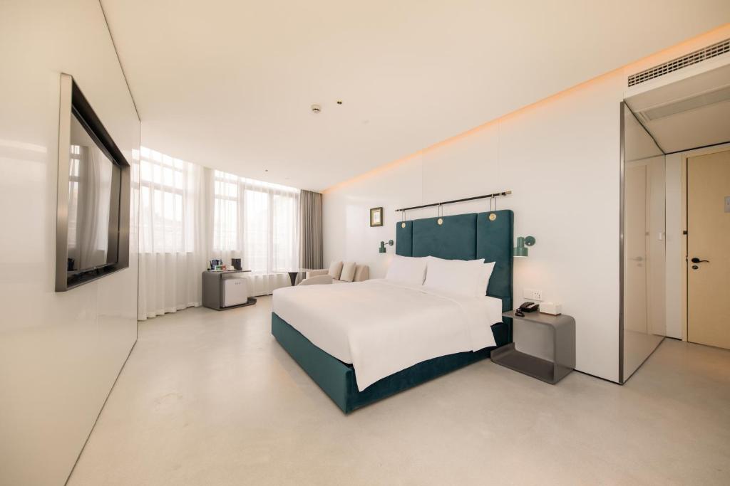 Postel nebo postele na pokoji v ubytování Shanghai Autoongo Bund Hotel
