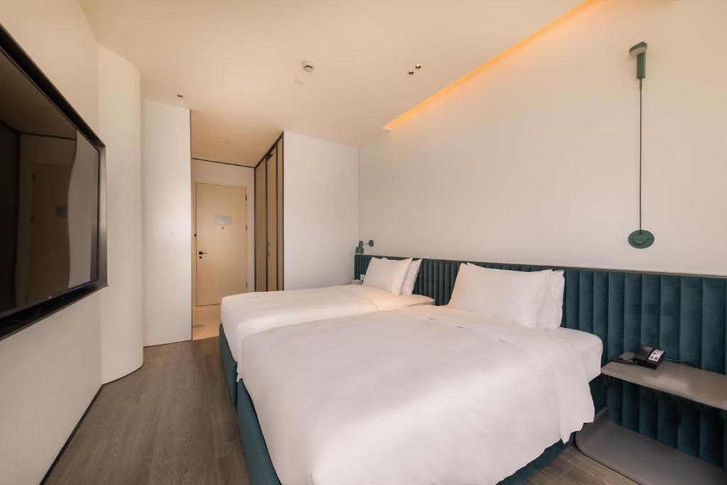 Postel nebo postele na pokoji v ubytování Shanghai Autoongo Bund Hotel