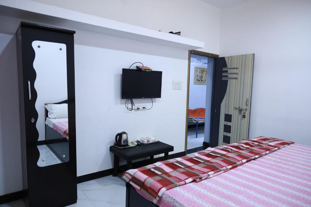 a bedroom with a bed and a tv on a wall at HOMESTAY ( EAGLE NEST ) in Bhuj