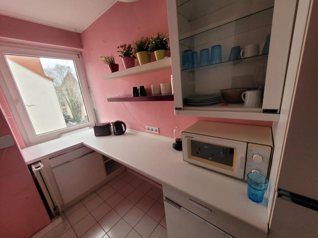 a kitchen with a white counter and a microwave at JAMYS Wohnung in Bremen