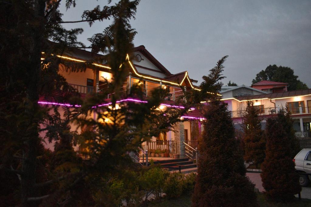 a house with christmas lights on the front of it at Shri Shail Inn Mukteshwar in Mukteshwar