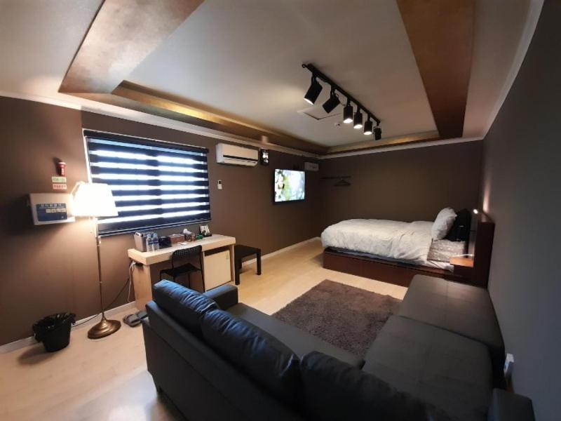 a living room with a couch and a bed at Cheongju Soo stay in Cheongju