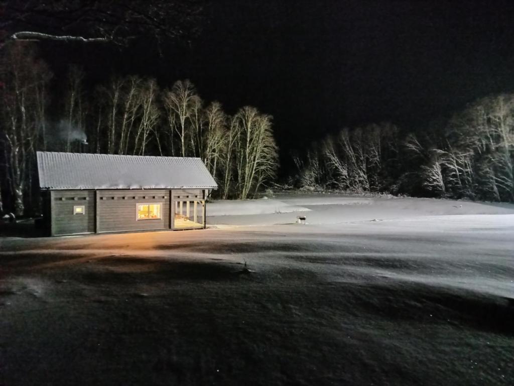 KupiškisSodyba vienkiemyje "Šeimos slėnis"的夜晚在田野的小小屋