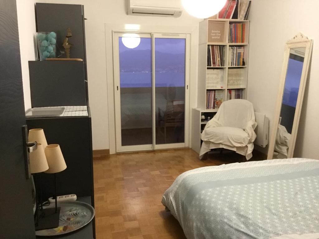 a bedroom with a bed and a chair and a window at Ajaccio . chambre avec vue in Ajaccio