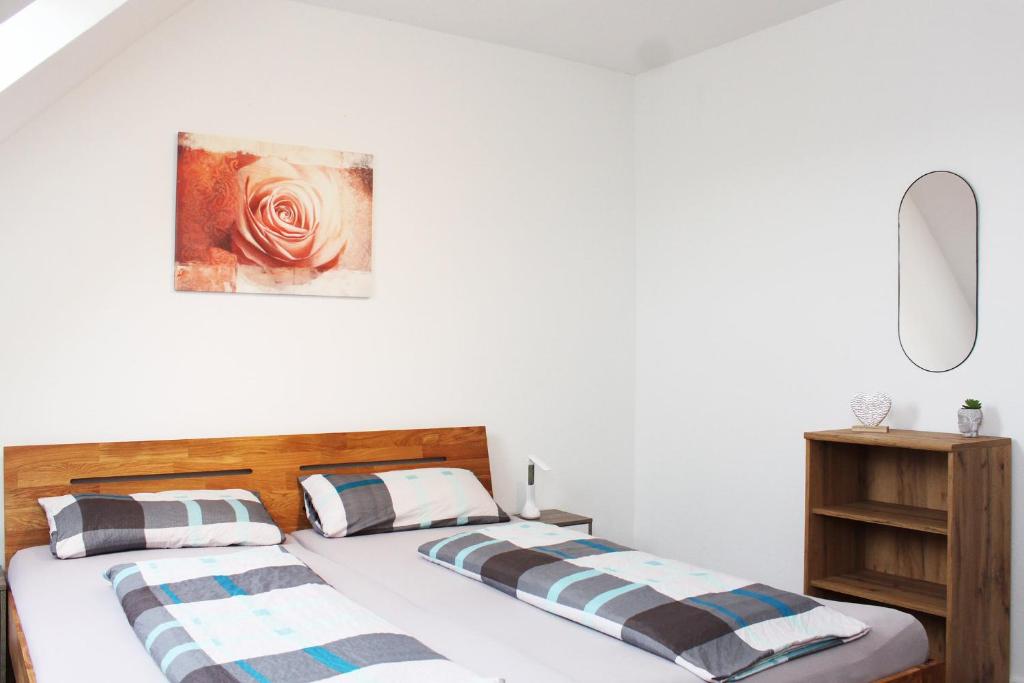 a bedroom with two beds and a painting on the wall at Ferienwohnung Zum Gerdautal in Böddenstedt