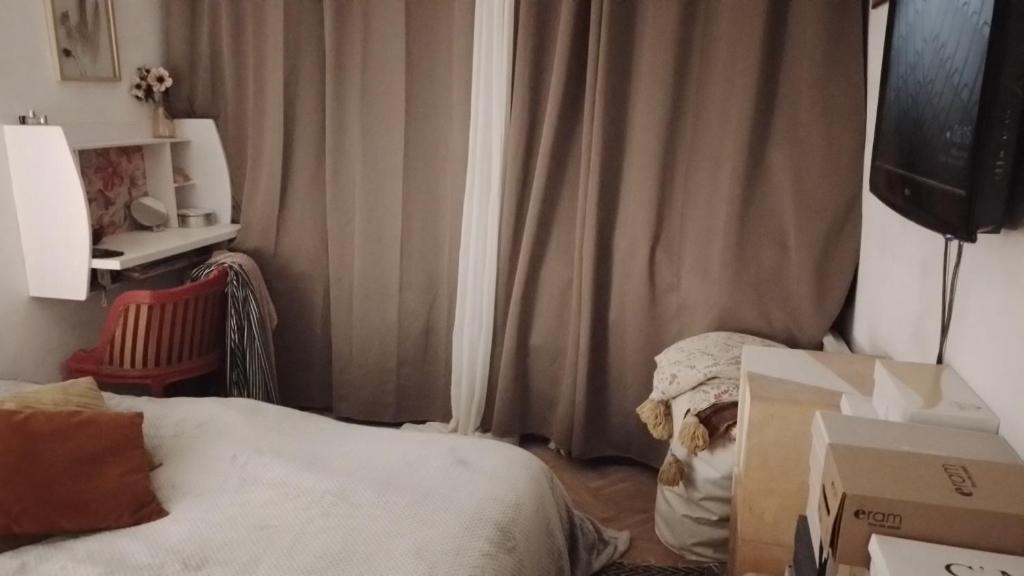 une chambre avec un lit et quelques boîtes dans l'établissement Charmante chambre spacieuse et lumineuse, à Paris