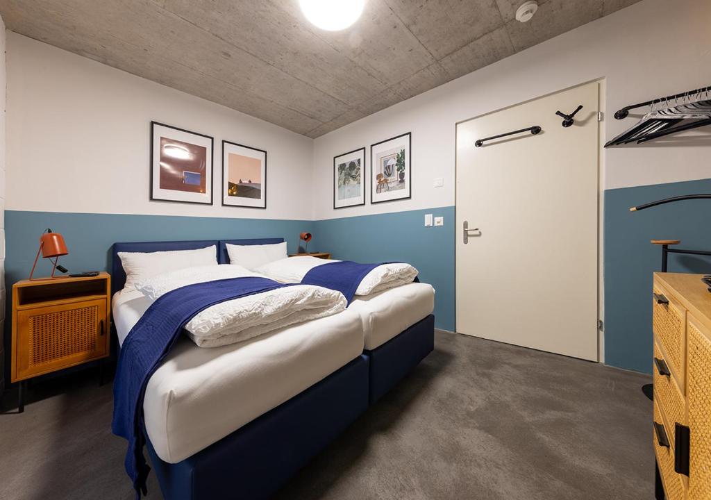 a bedroom with two beds with blue and white walls at Ambrosia Hüsli in Rheinfelden