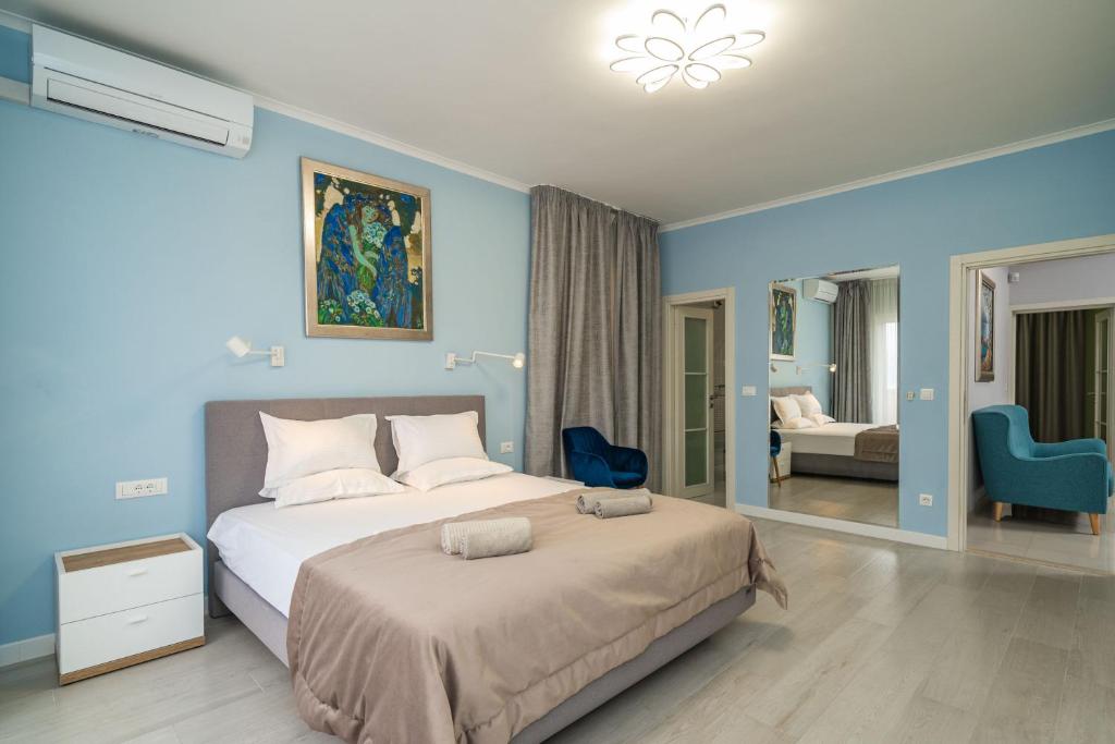 een slaapkamer met een groot bed met blauwe muren bij Villa Laperosa in Cavtat