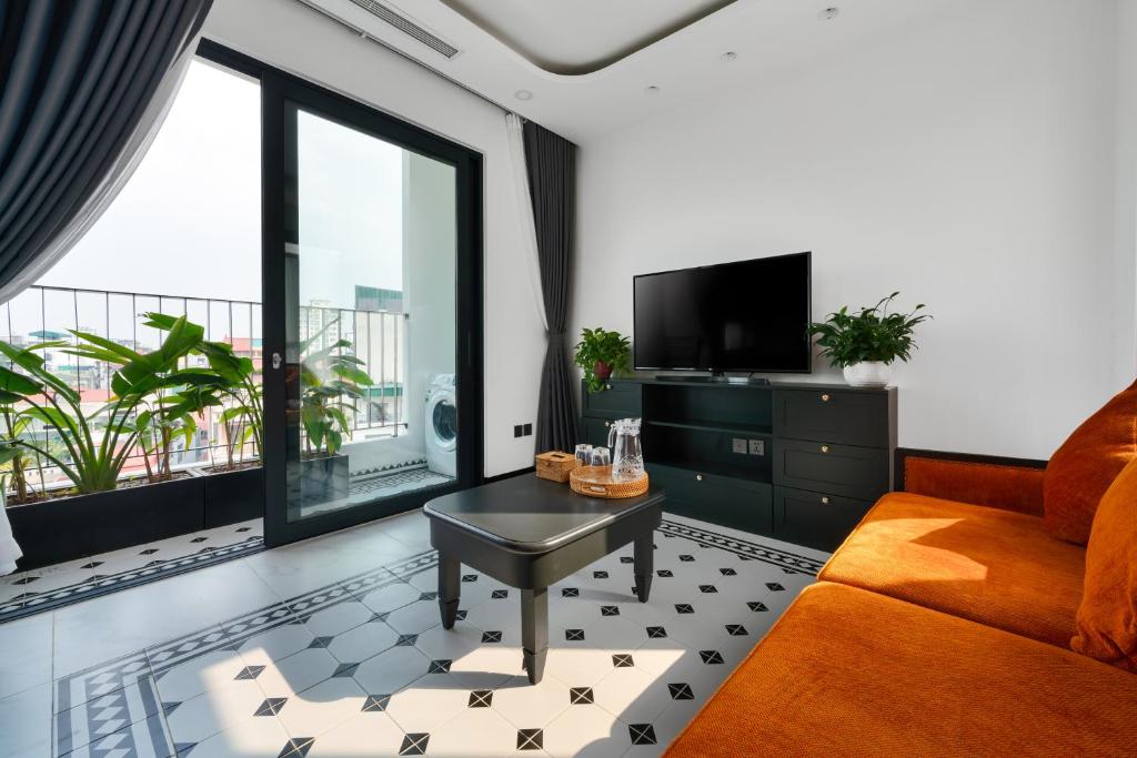 a living room with a couch and a tv at The Galaxy Home Doi Can Hotel and Apartment in Hanoi