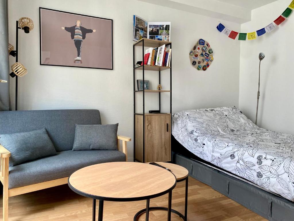een slaapkamer met een bed, een bank en een tafel bij Appartement au coeur de Paris in Parijs