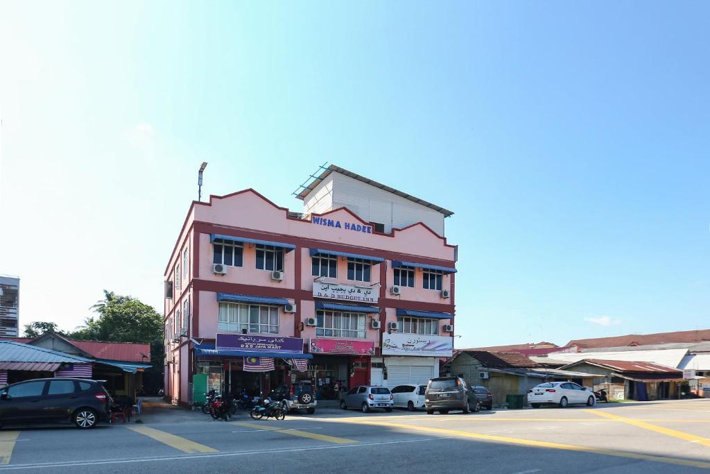 um edifício cor-de-rosa ao lado de uma rua em OYO 89755 D&d Budget Inn em Kota Bharu