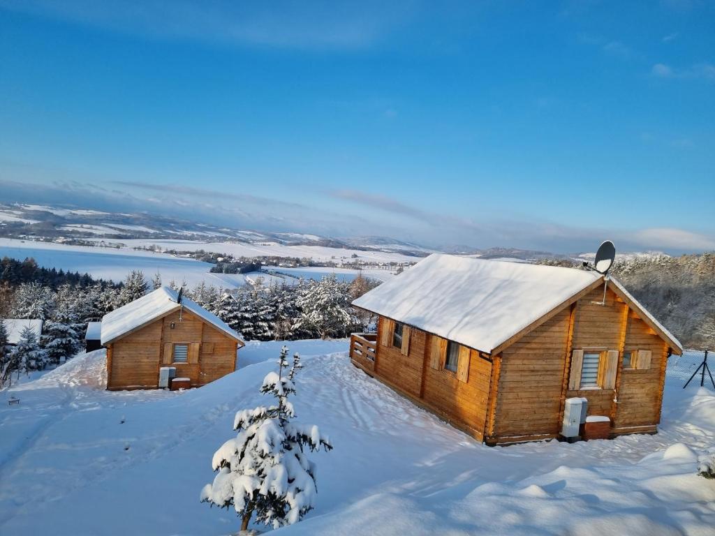 two wooden cabins in the snow at Huberkowe Domki in Swiecko