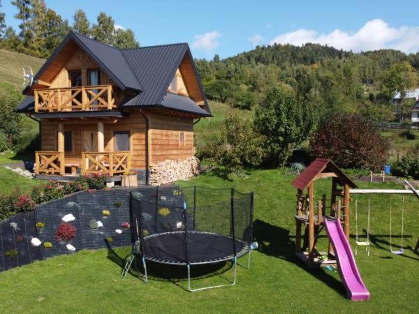 a house with a playground in front of a house at Familiówka in Mizerna