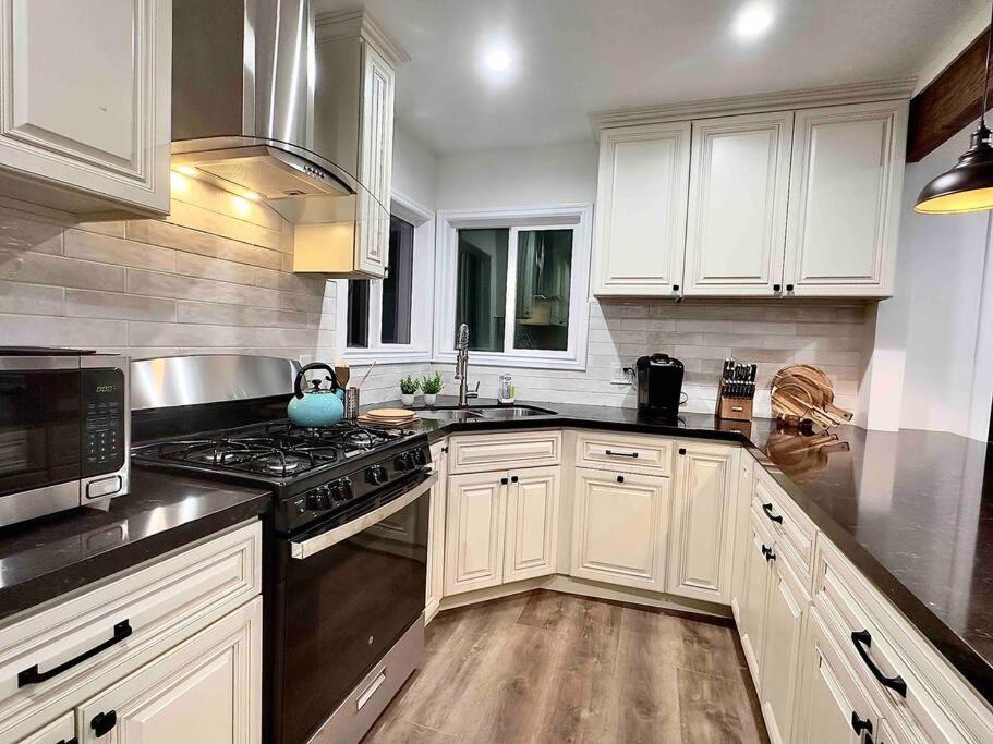 uma cozinha com armários brancos e um forno com placa de fogão em LA Living near SoFI-LAX-Beach _House em Los Angeles
