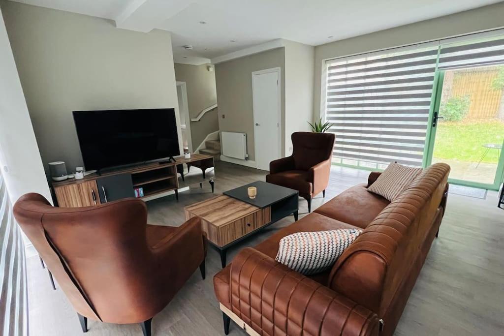 sala de estar con sofá, sillas y TV de pantalla plana en A house designed for you…, en Edmonton