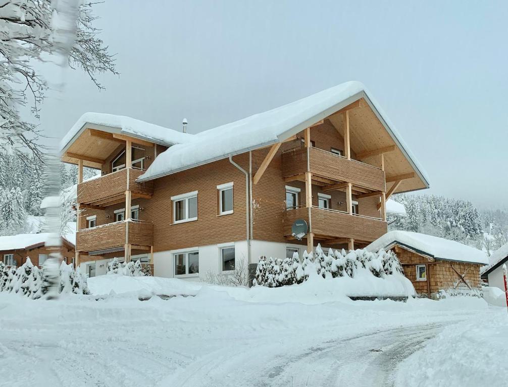 a building covered in snow with a lot of snow at Ferienwohnungen Probst in Ofterschwang