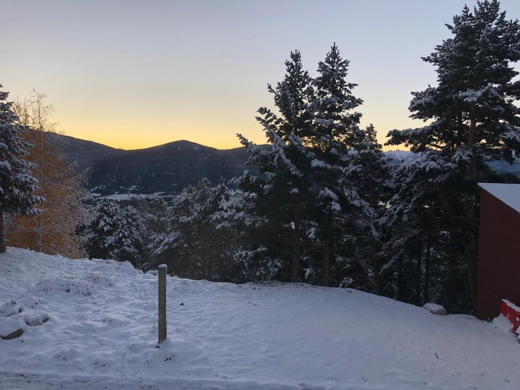 a snow covered hill with trees in the distance at Les Jonquilles in Les Angles