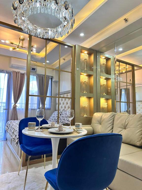 a living room with a couch and a table and chairs at Deluxe Suites Razelles 2 at Shore 2 Residences Tower 1 in Manila
