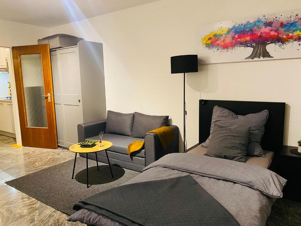 ein Wohnzimmer mit einem Bett und einem Sofa in der Unterkunft Schönes Wohnen in Groß-Buchholz - Zentral+Modern in Hannover