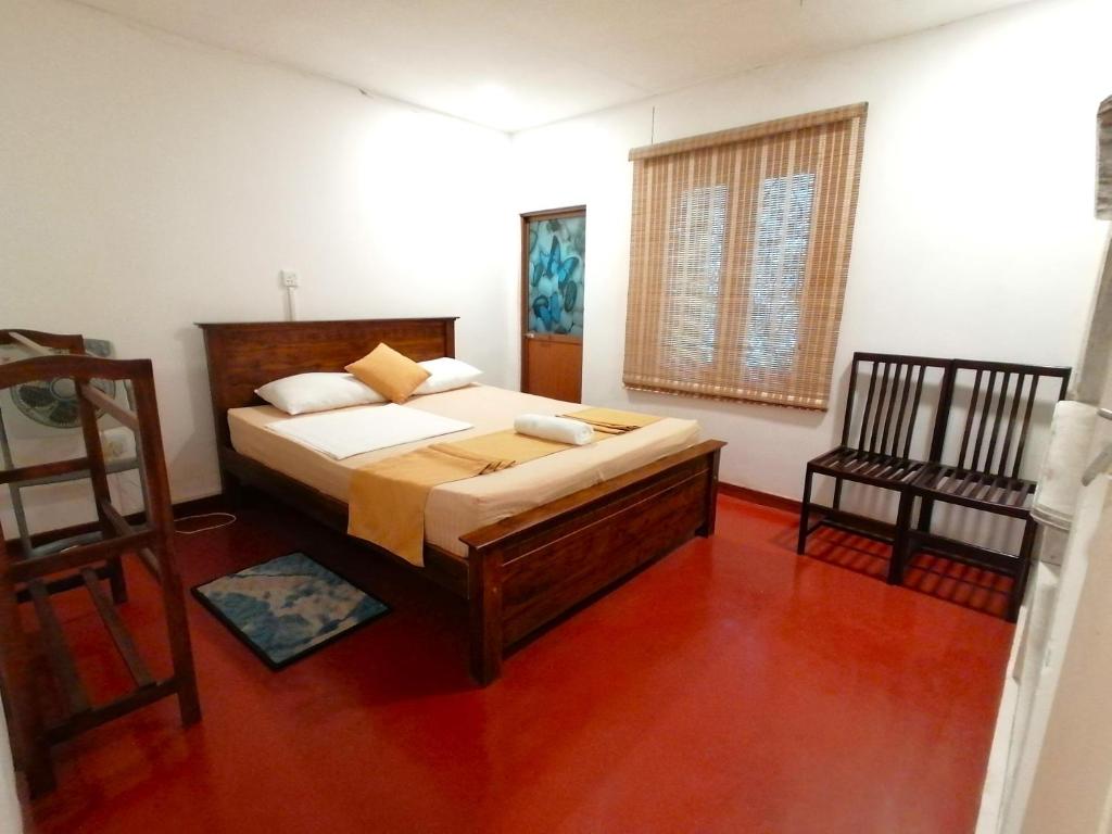 a bedroom with a bed and a chair in it at Bambara Ella Agro Resort & Camping in Haputale