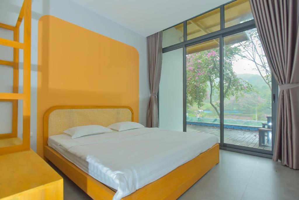 a bedroom with a bed and a large window at Villa Ba Vi 6 Bedrooms & Pool DC Green Resort in Hanoi