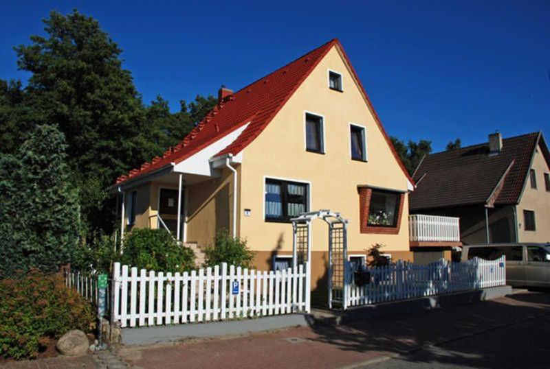 a large house with a white picket fence at Ferienwohnung zur Baaber Heide in Baabe
