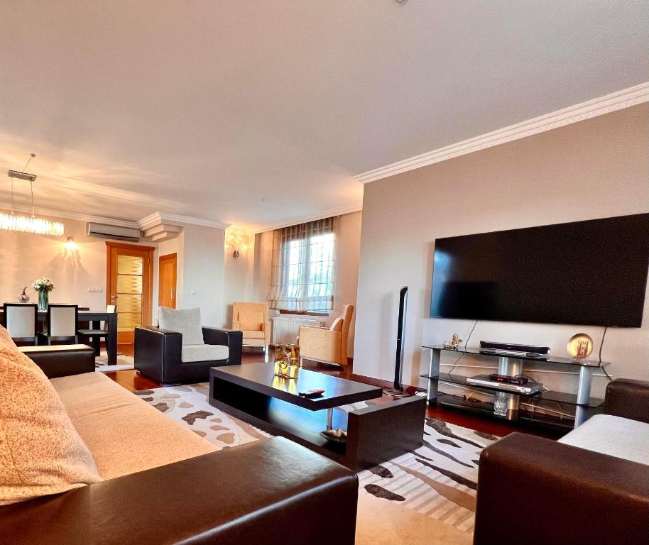 ein Wohnzimmer mit einem großen Flachbild-TV in der Unterkunft Amazing Luxury 4 BR Apt 200m2 at Fenerbahçe, Best Location in Istanbul