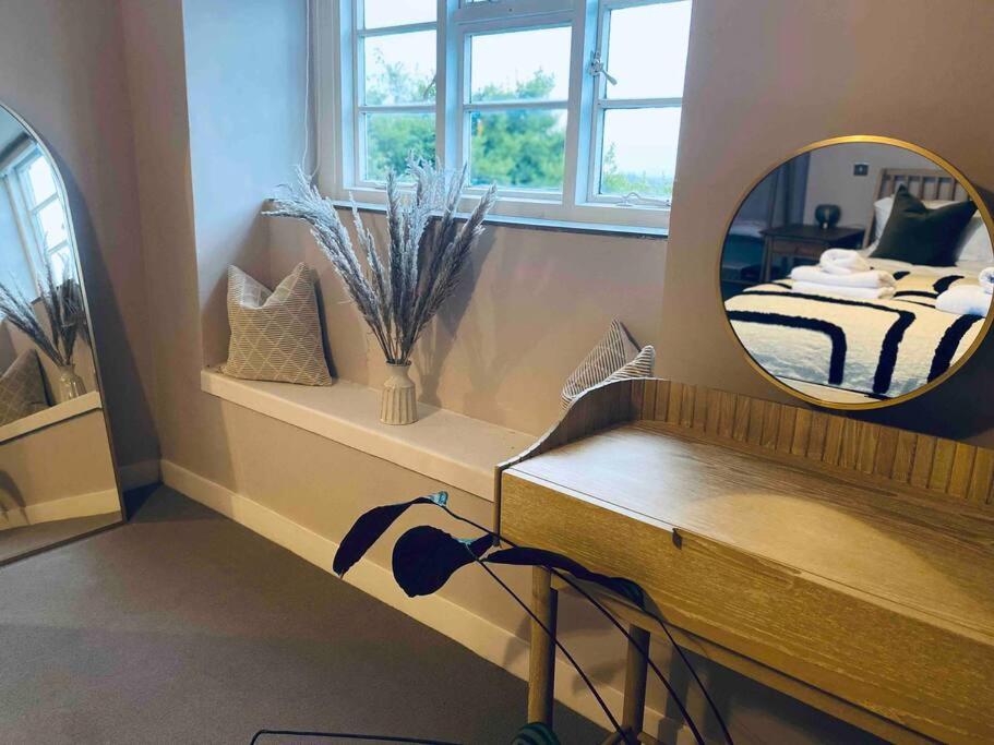 un bagno con specchio e un letto in una camera di Boutique, weaver’s cottage. Views a Bradford on Avon