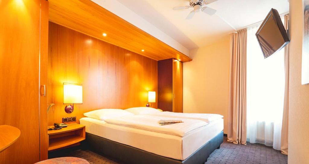 Кровать или кровати в номере Victor's Residenz-Hotel Frankenthal