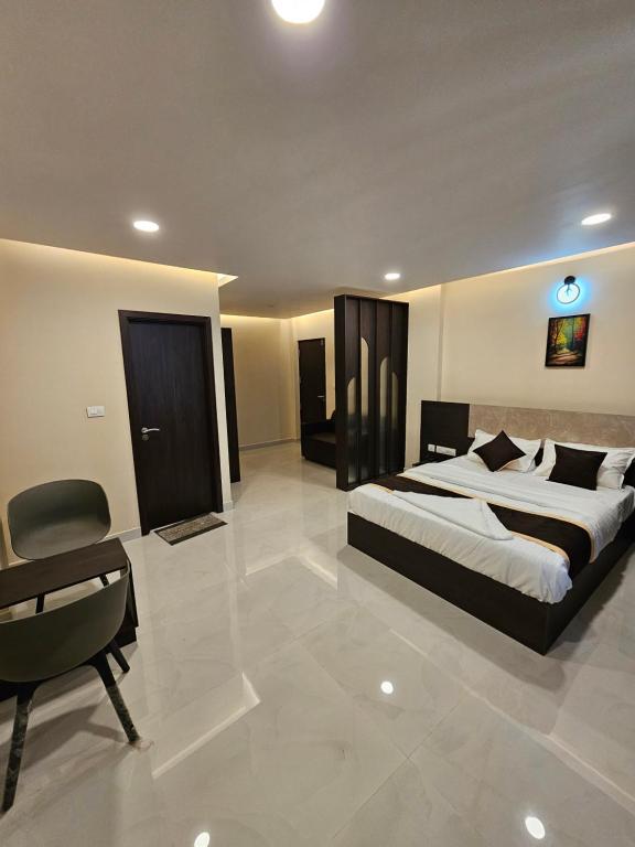 a bedroom with a large bed and a chair at THAAL RESIDENCY Cheruvathur-HALA GROUPS in Nīleshwar
