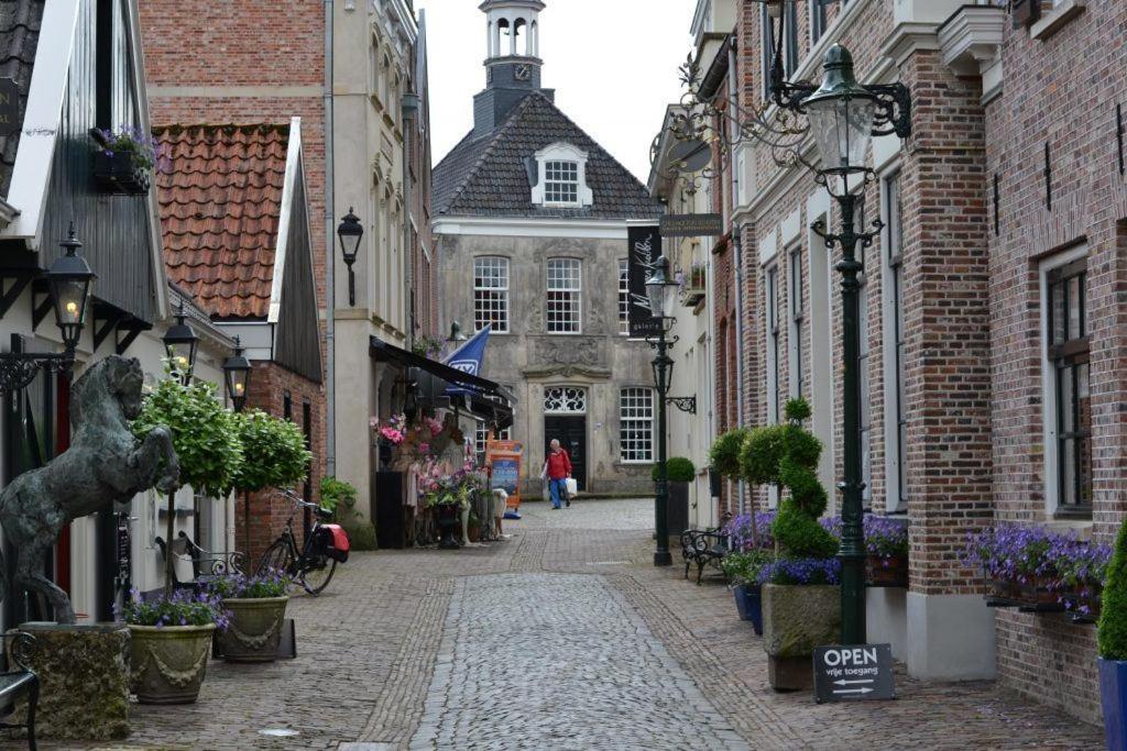 an alley with buildings and a woman walking down the street at Camping de Haer in Ootmarsum